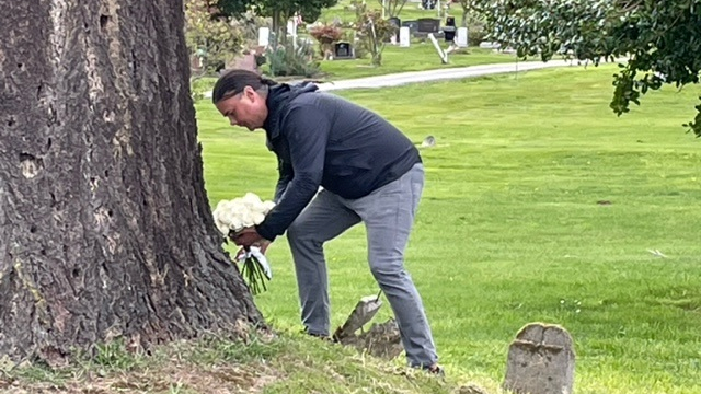 ASIA Newland lays flowers on a gravesite. 